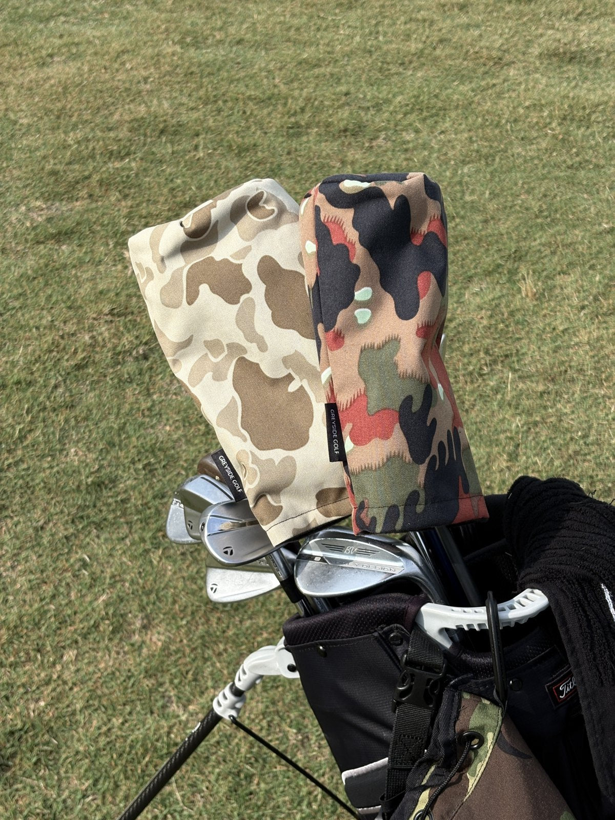 The Beach Side desert frogskin and The KSK Swiss Alpenflage headcovers in a golf bag on the course