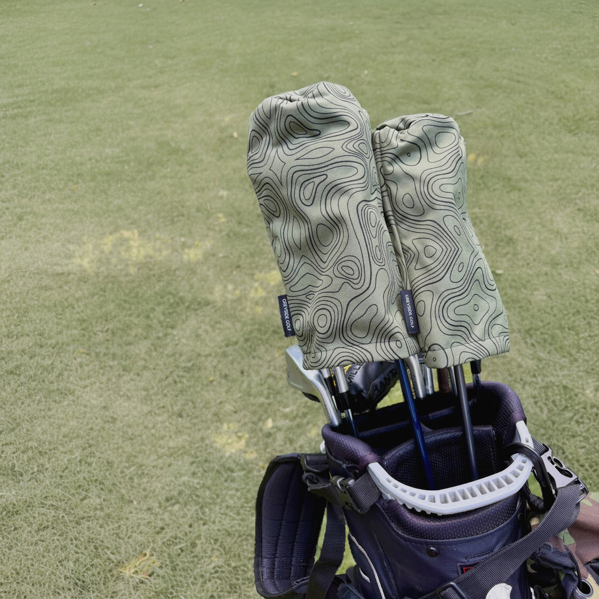 The Azimuth green topographic headcovers on driver and wood in golf bag on course